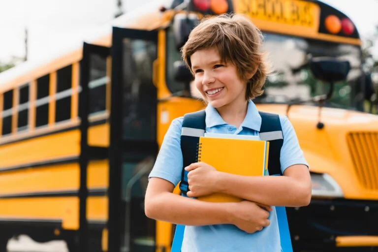 Young caucasian schoolboy kid pupil student holding copybooks and books preparing for school